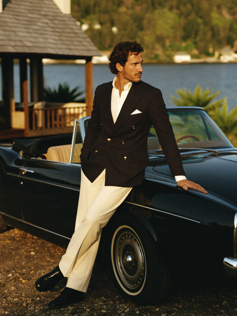 Man in navy blazer by vintage convertible